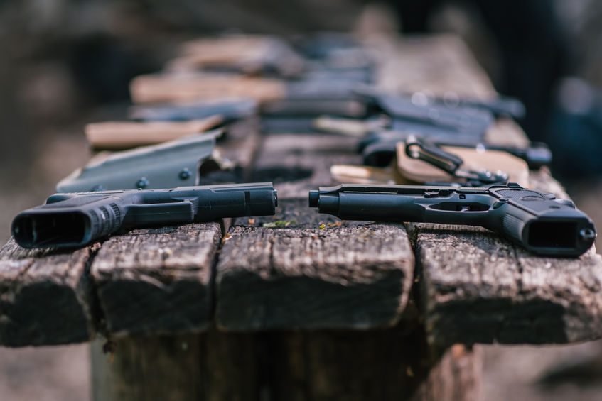 pistols for shooting sports lie on a wooden table