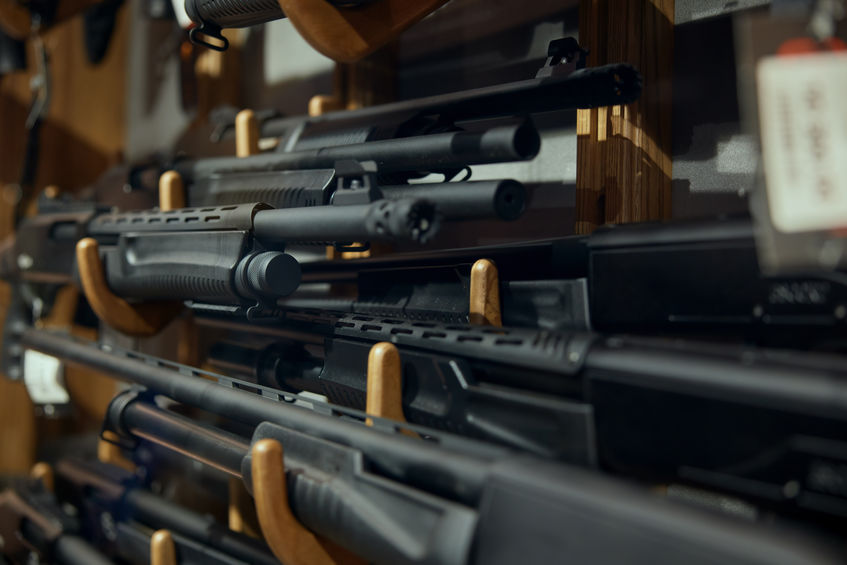 Gun machine and rifle assortment on rack at weapon store. Armed equipment distribution and merchandise